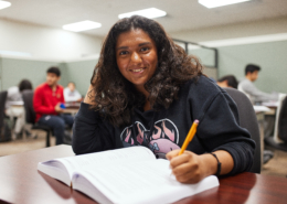 A high school student studying at a desk to raise her GPA.
