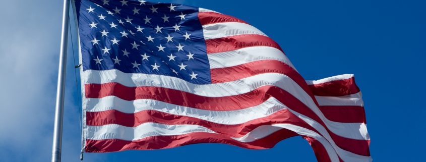 us flag waving against a blue sky