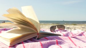 book and sunglasses on the beach