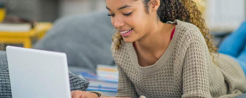 female high school student studying with laptop