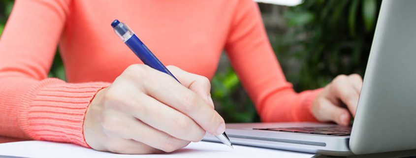 young woman with a laptop and pen